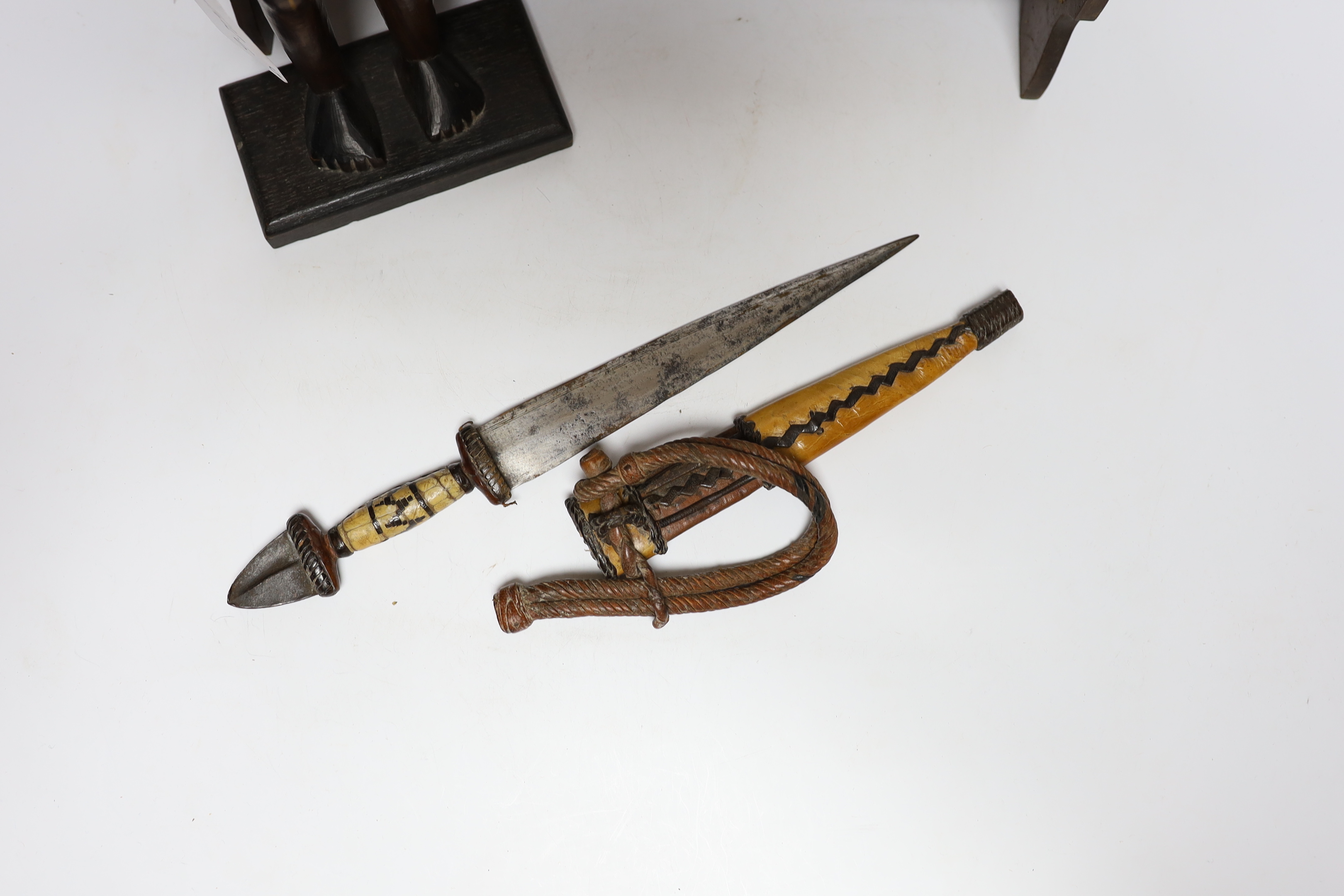 A collection of tribal items including a fabric doll, an African carved wood figure and a dagger and bow, bow 166cm long